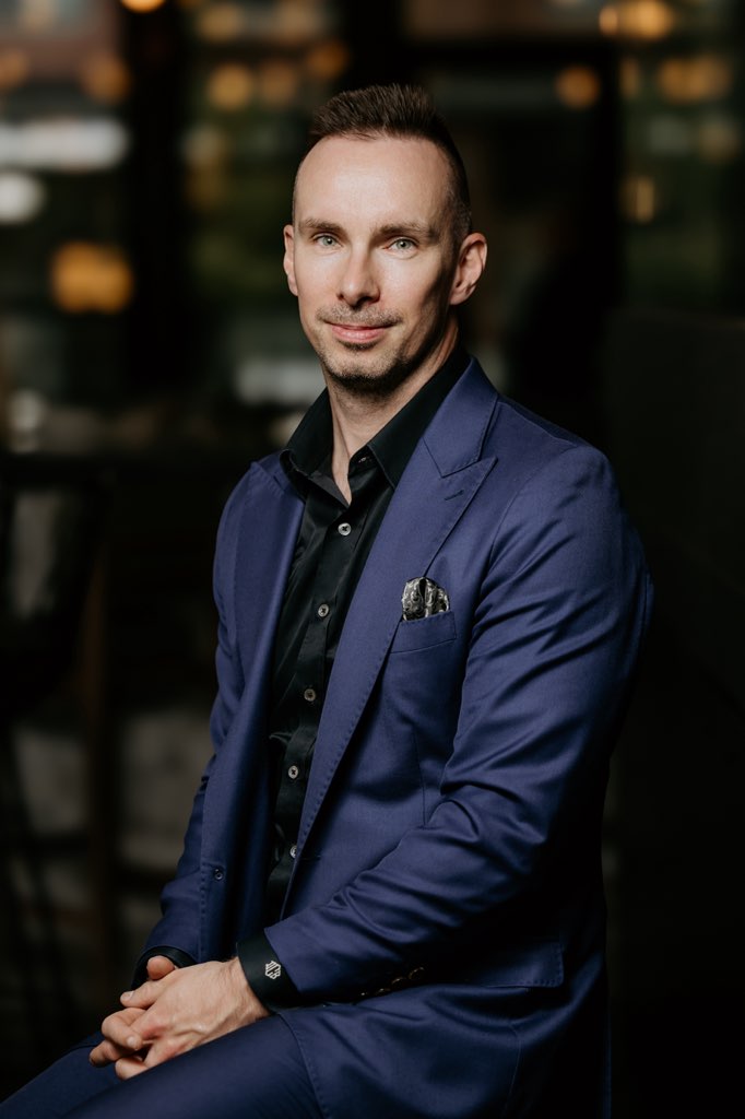 A man in a navy blue suit with peak lapels