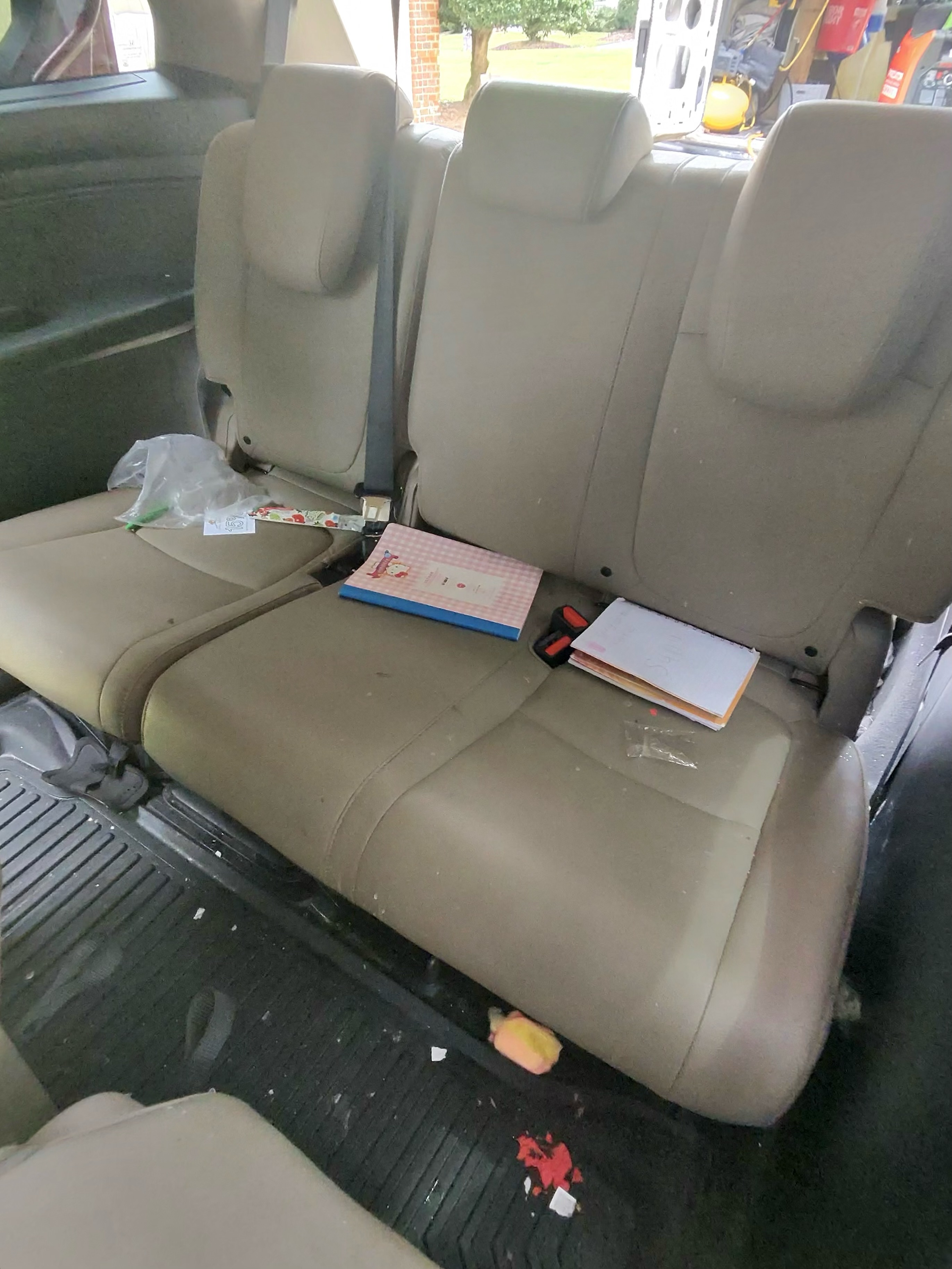 Vehicle back seat area cleaned and emptied with a few items remaining