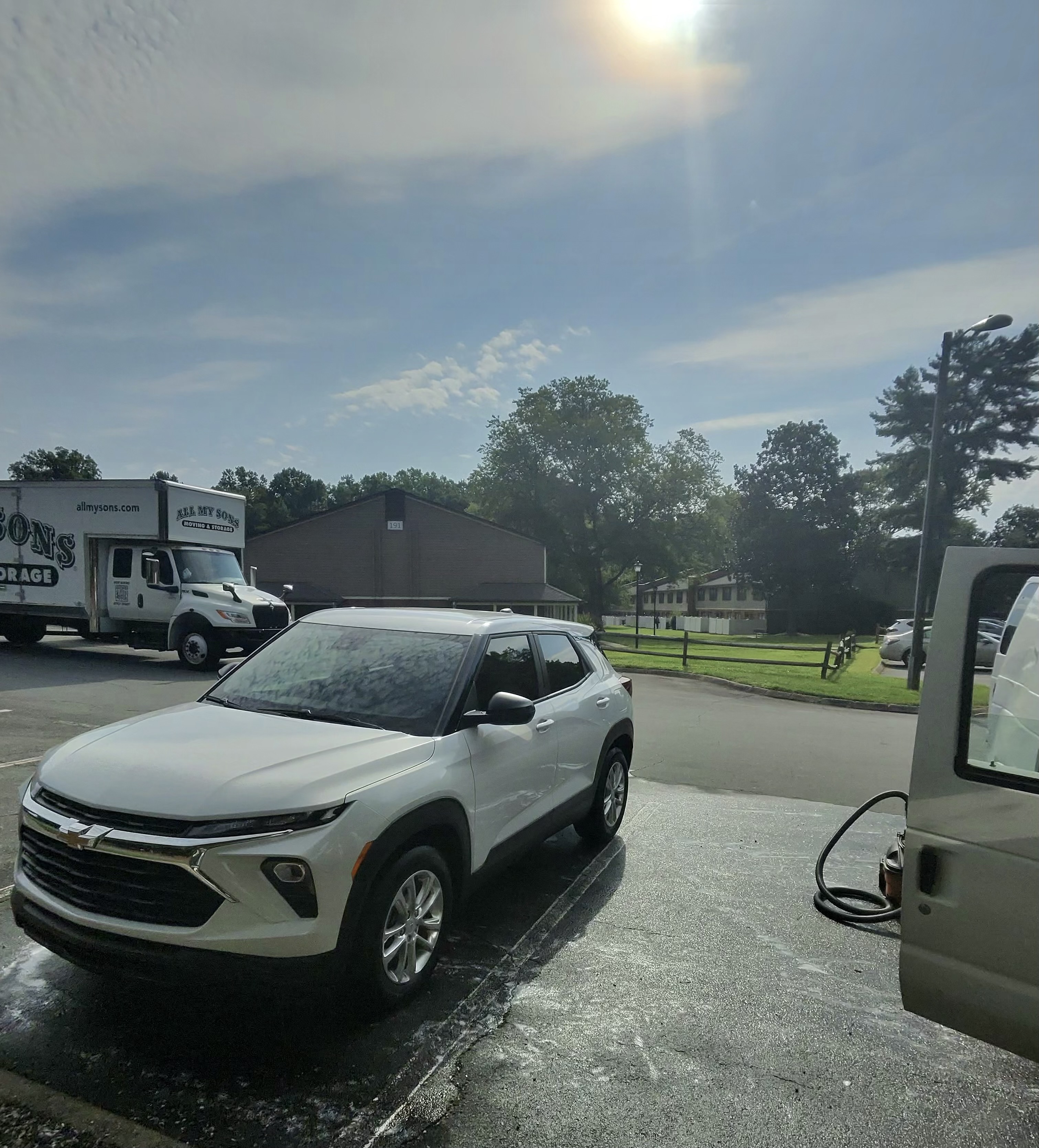 White car with glossy paint in a parking lot after detailing