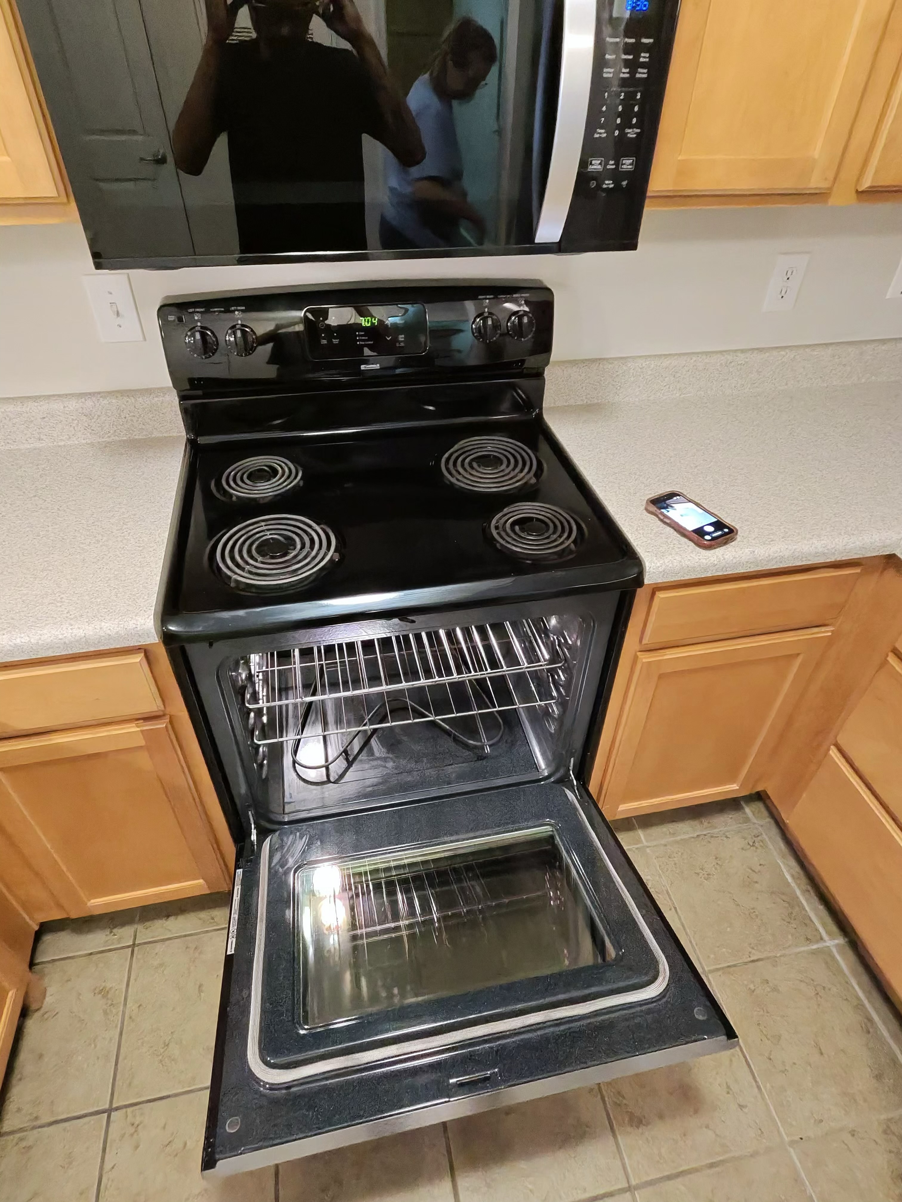 Kitchen with a clean electric stove and microwave after deep cleaning
