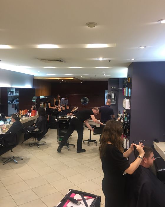 The salon floor, stylists with clients