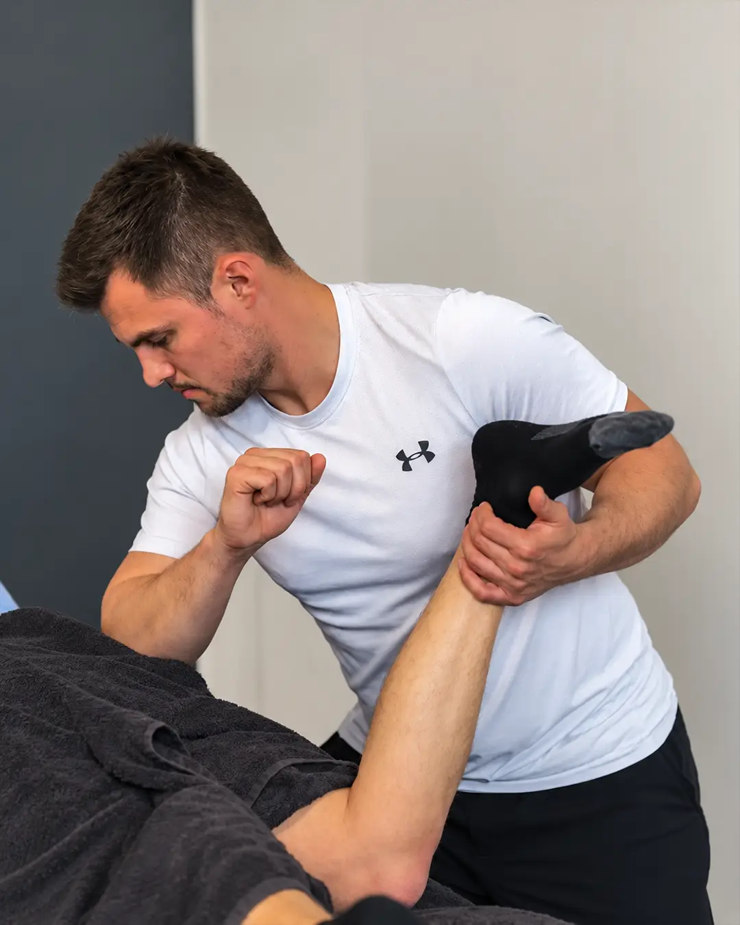 Oli stretching a client's hamstring on the treatment couch