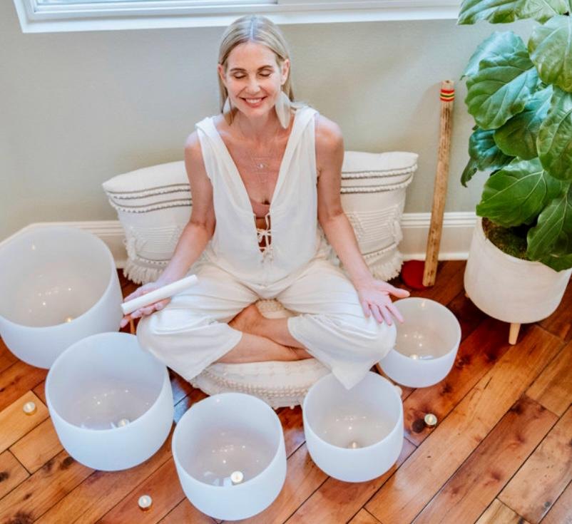 Sandra seated among crystal singing bowls