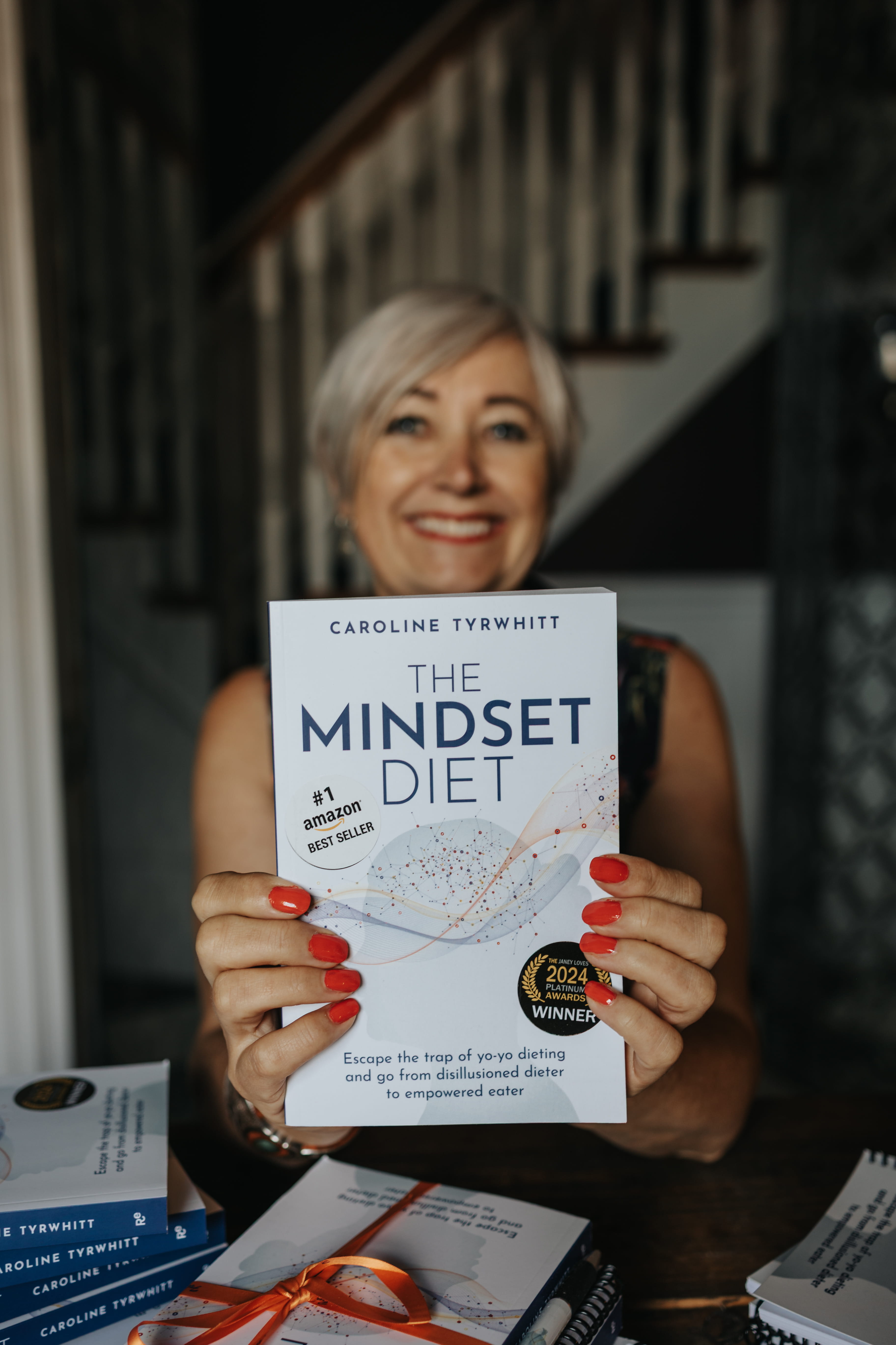 Caroline Tyrwhitt holding The Mindset Diet book