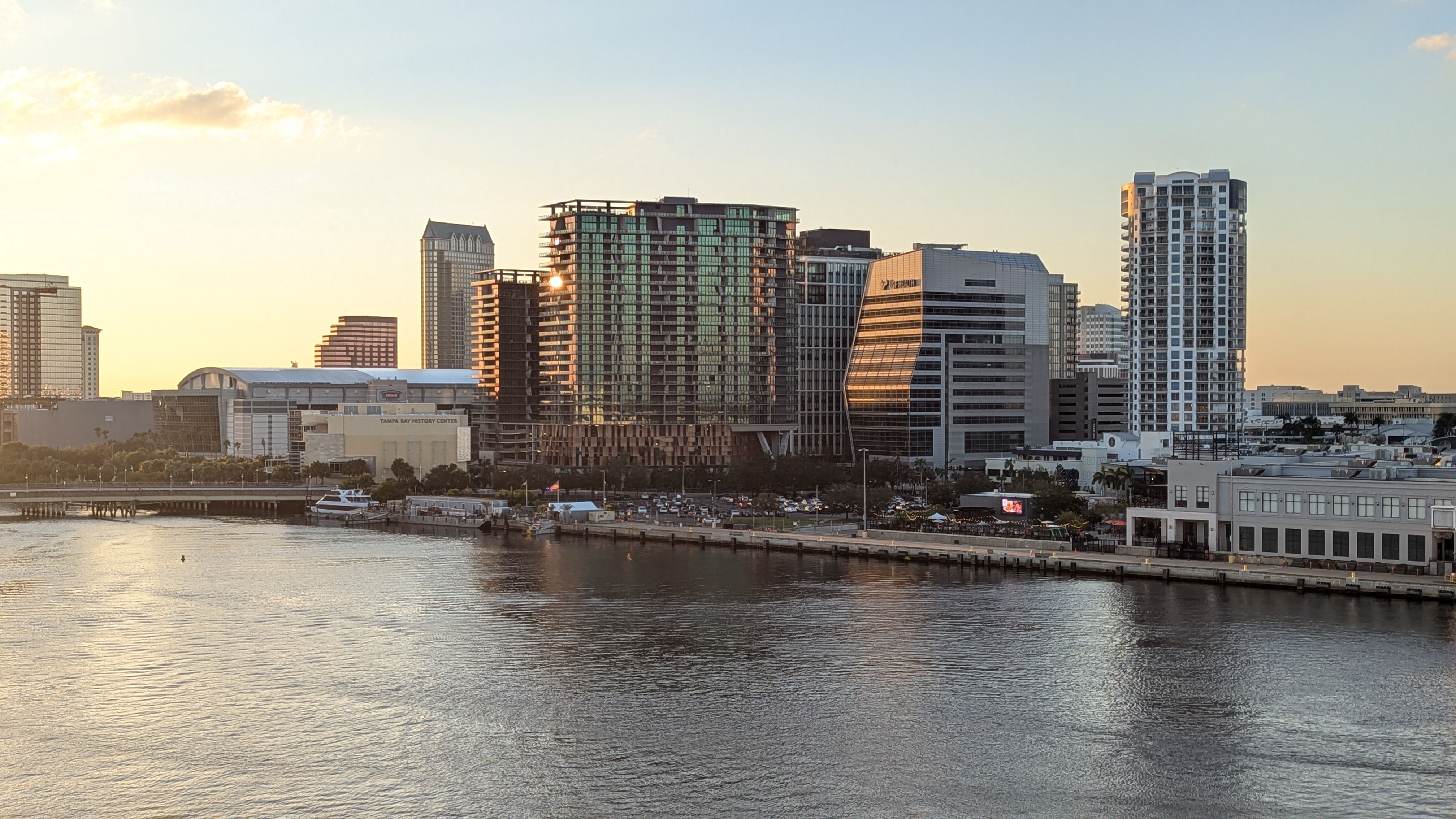 Vista panorámica del centro de Tampa, Florida, al atardecer, con edificios reflejados en el agua.