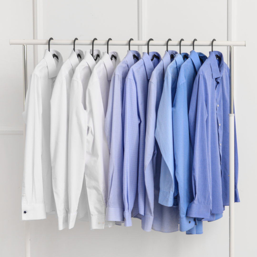 Clean dress shirts hanging on a rack.