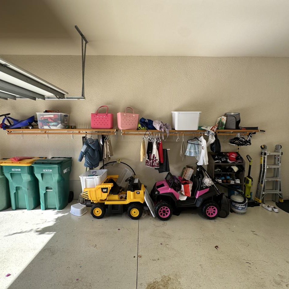 Garage before: one wire shelf, ride-on toys, bins and gear on the floor