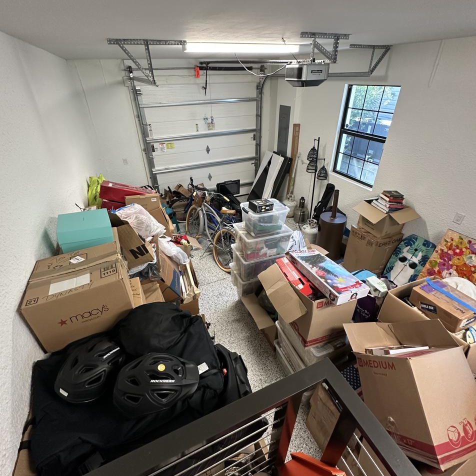 Garage before: moving boxes, bins and bikes filling the floor