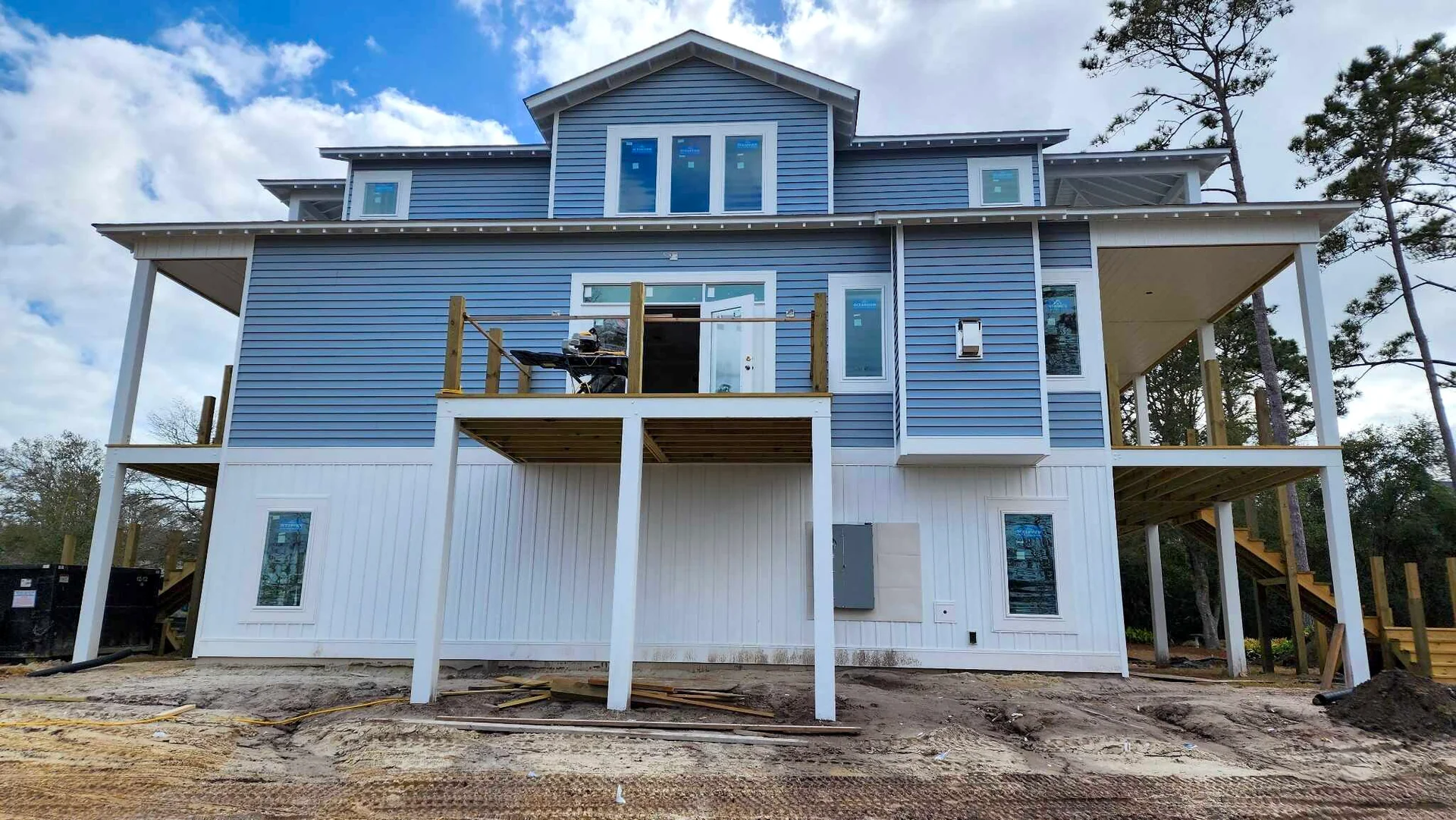 Blue siding and white trim on a raised coastal home