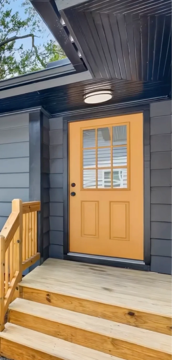 Windows and doors set beneath a wraparound porch
