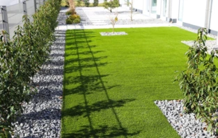 Moderner Garten mit Rasen, Steinplattenweg und Holzpergola entlang des Hauses