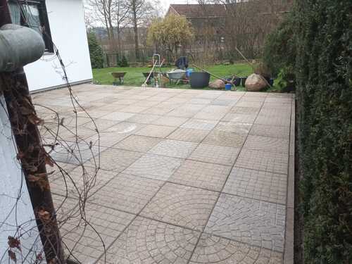 Terrassenfläche aus Betonplatten im Läuferverband mit sauberer Fuge neben Rasenfläche