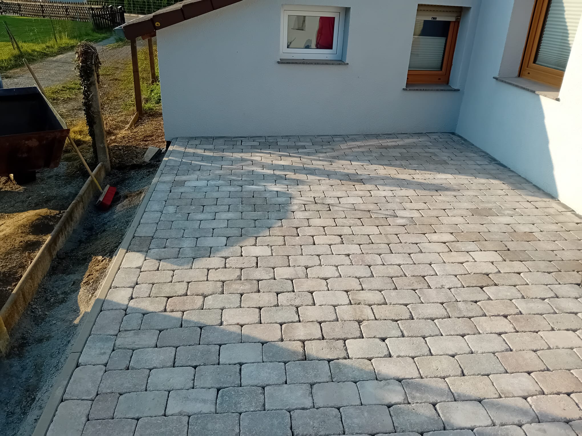 Hofeinfahrt aus Betonpflaster mit Entwässerungsrinne vor Garage