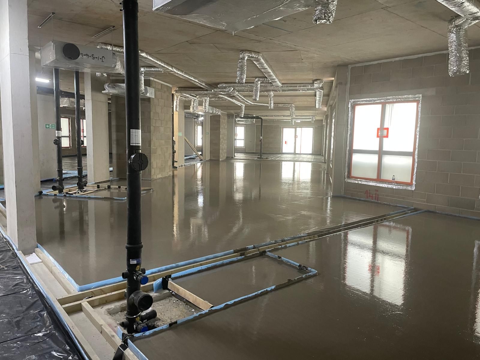 A finished flowing screed floor plate with levelling pins at Brentford Lock