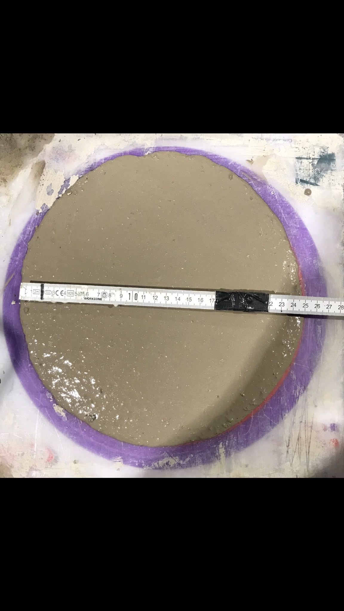 A ring of flowing screed spread on a test board to check consistency at Brentford Lock