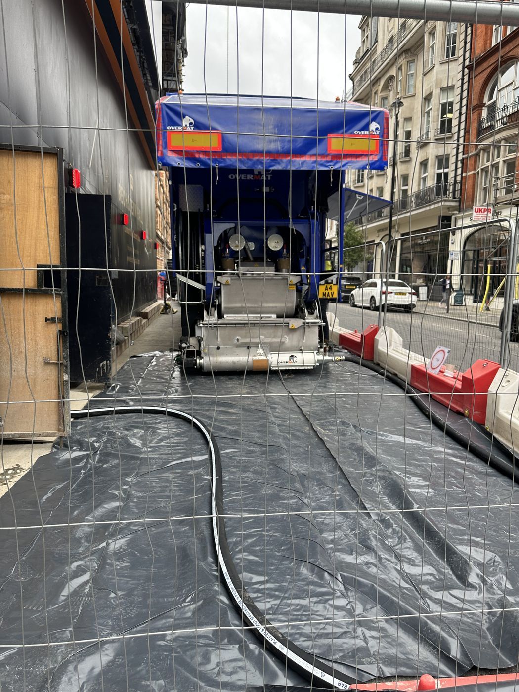 The Maverick in a narrow pit lane with the screed pump line running into the building
