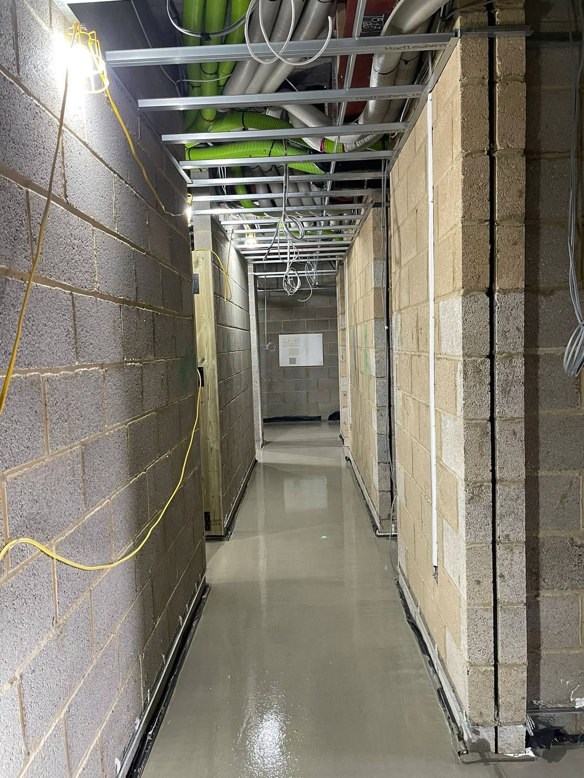 A finished flowing screed floor in a residential hallway between stud walls