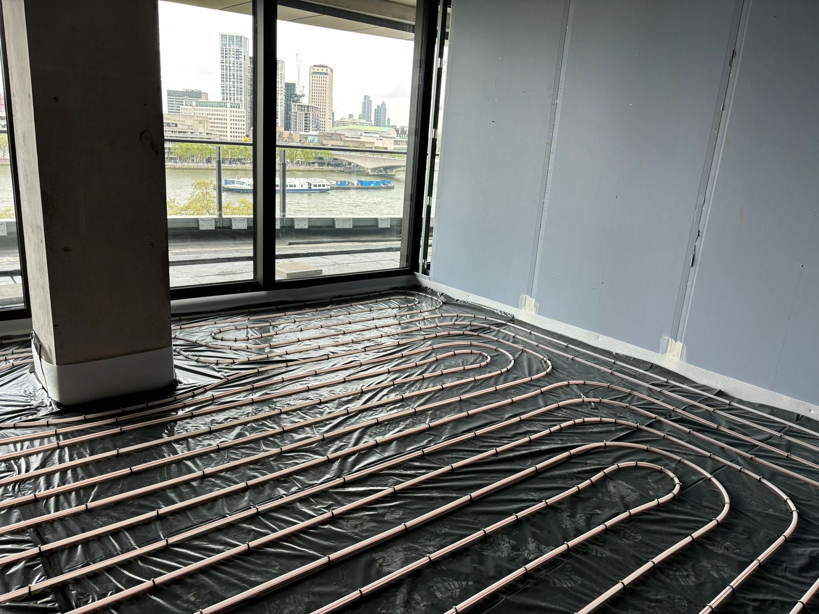Underfloor heating pipes laid on insulation ready for screed in a riverside apartment