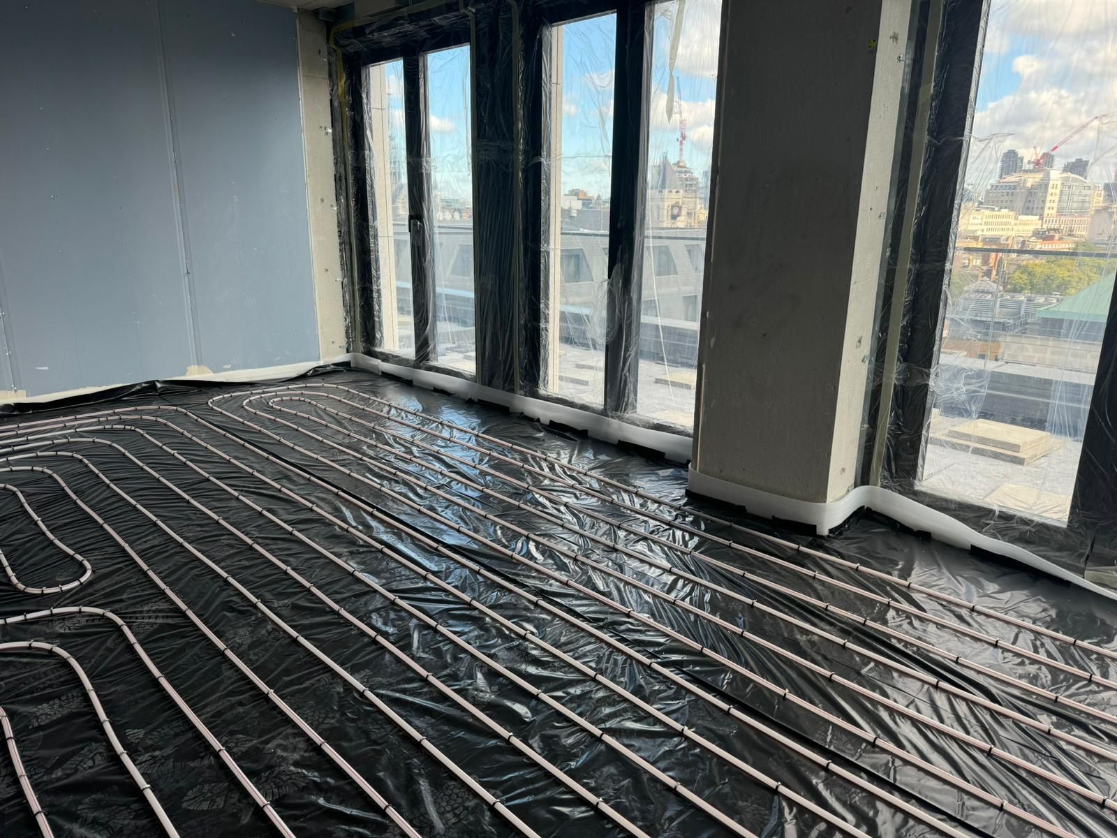 Underfloor heating pipework fixed across an apartment floor before the screed pour
