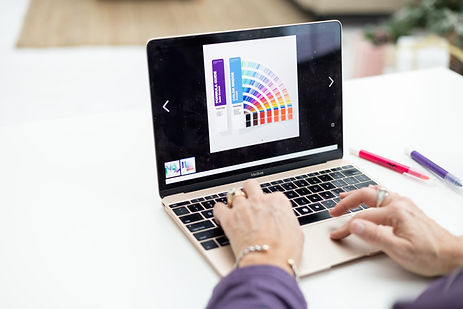 Person using a laptop displaying a colorful brand design and color palette. Person using a laptop displaying a colorful brand design and color palette.