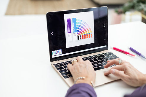 Person working on a laptop displaying a colorful branding design and color palette. Person working on a laptop displaying a colorful branding design and color palette.
