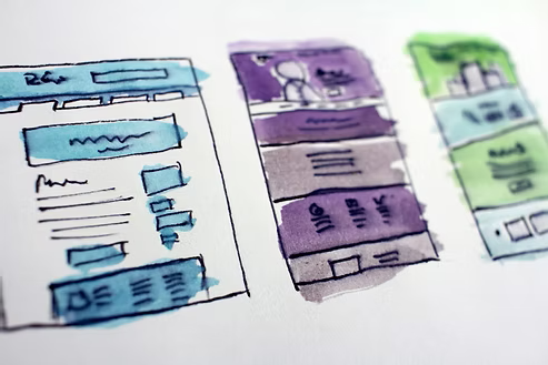 Hand-drawn website layout sketches in blue, purple, and green. Hand-drawn website layout sketches in blue, purple, and green.