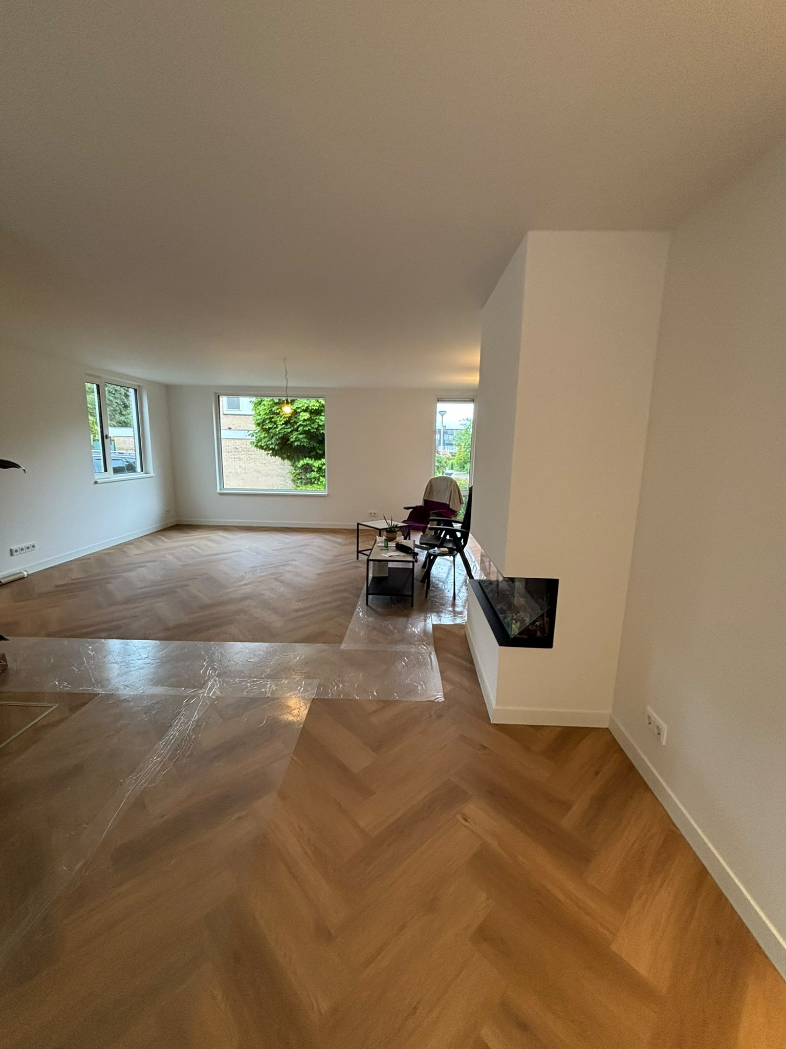 Woonkamer in Arnhem na complete renovatie met visgraatvloer en sfeerhaard