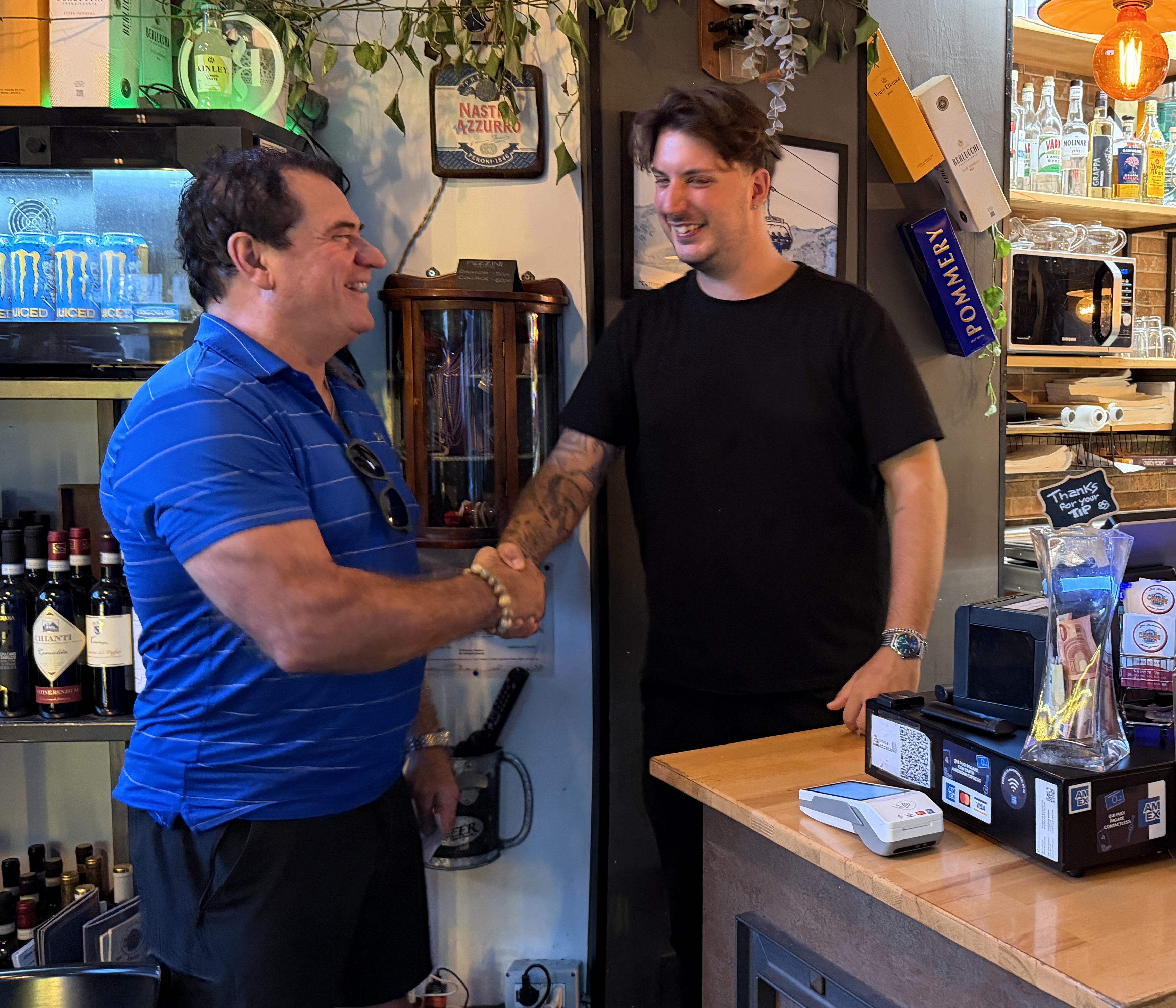 RepuBoostAI founder shaking hands with a restaurant owner behind the counter