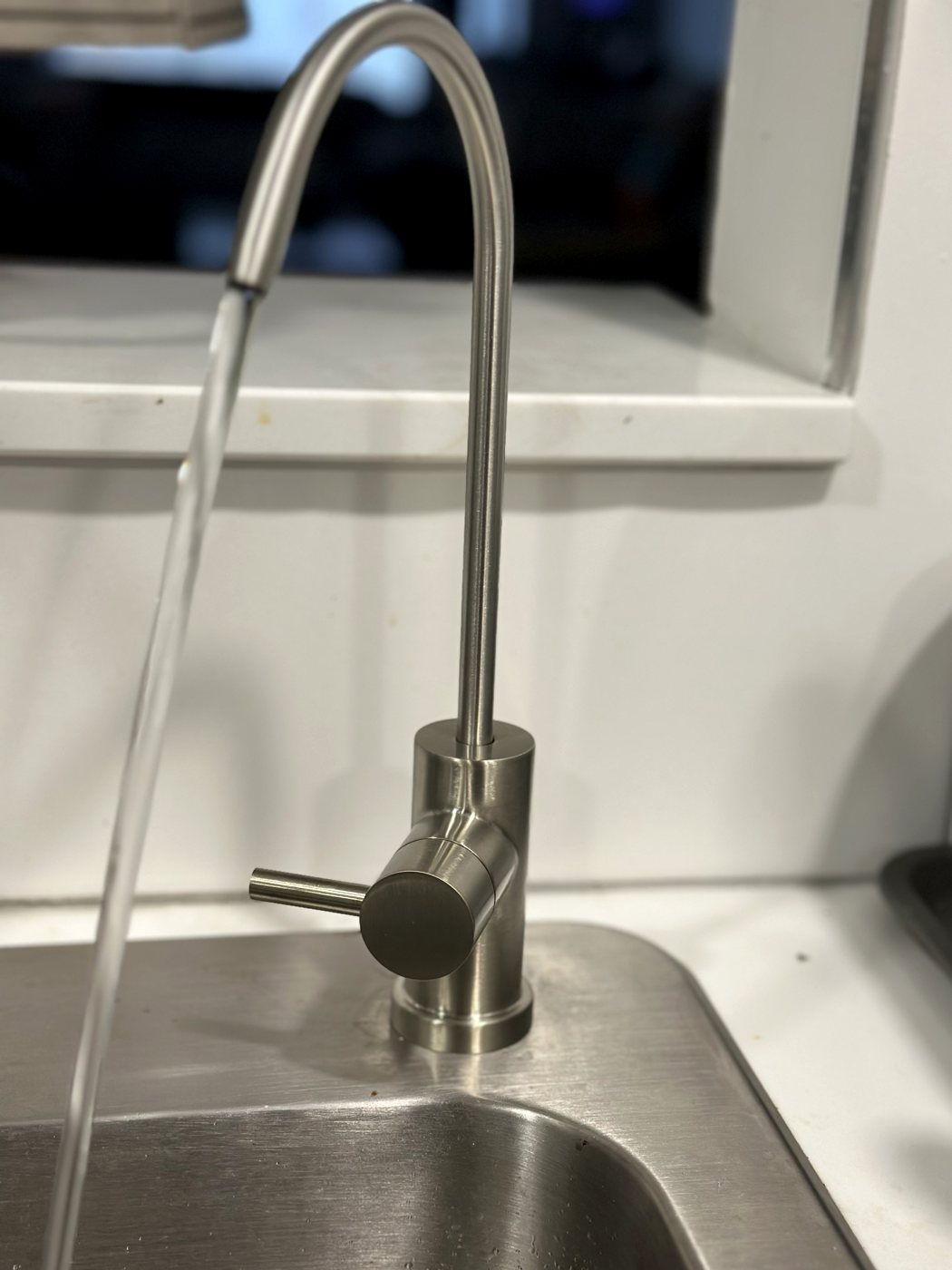 Brushed-nickel filtered water faucet installed at a kitchen sink