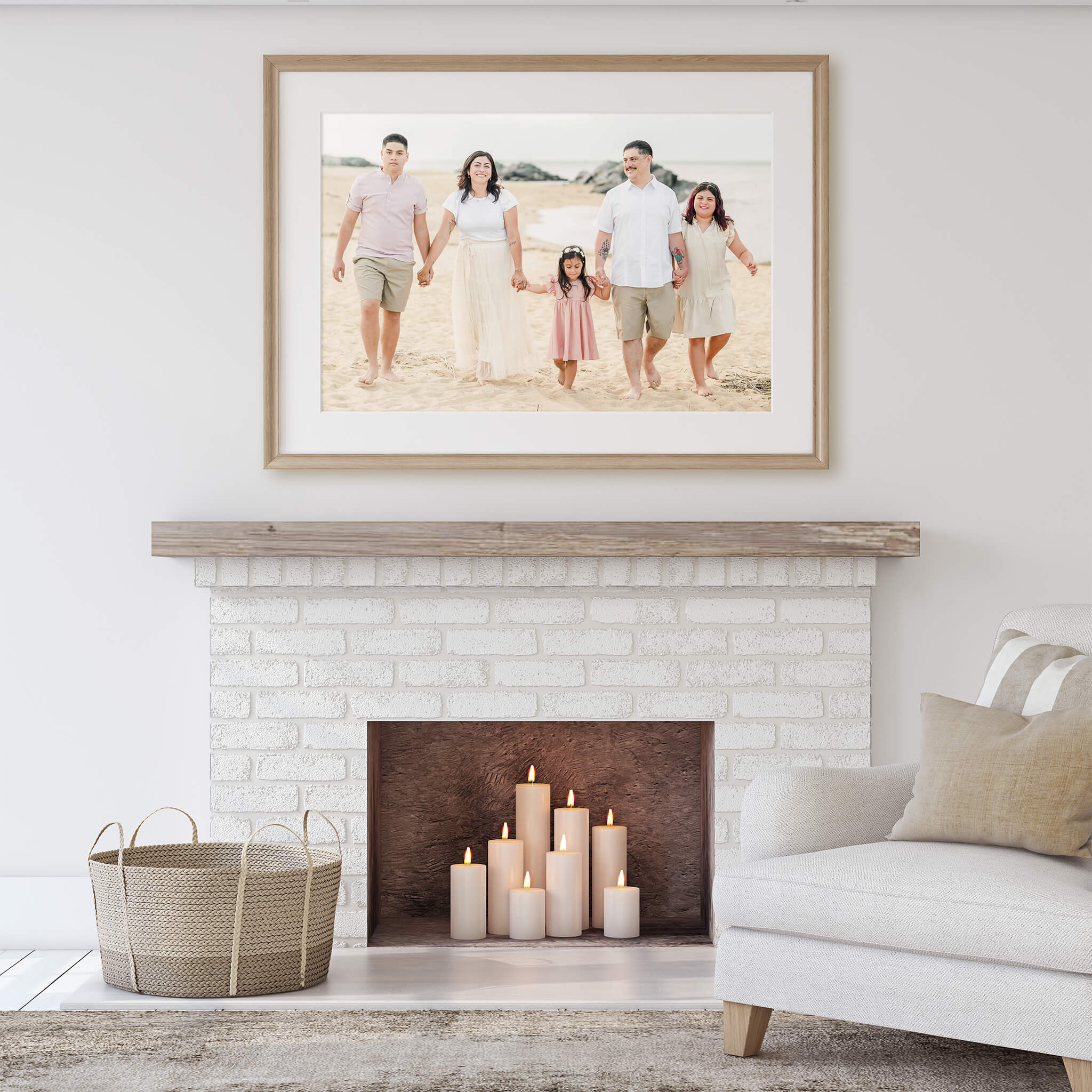 A large framed print of a family on the beach hangs over a fireplace. The room is white with neutral decor.