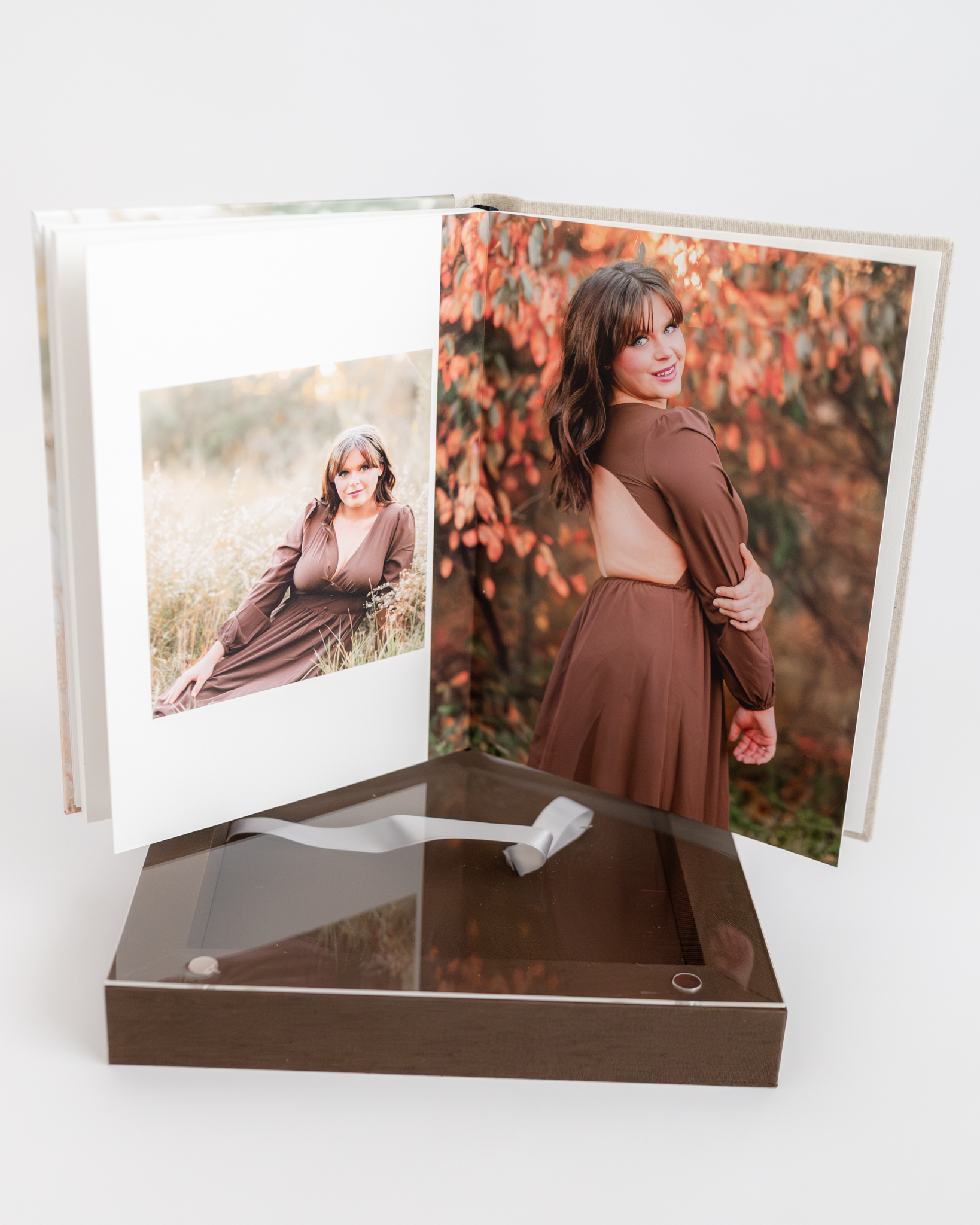 A photo of a high school senior's album. It is open to a page where he is wearing a brown dress and posing in a fall setting.