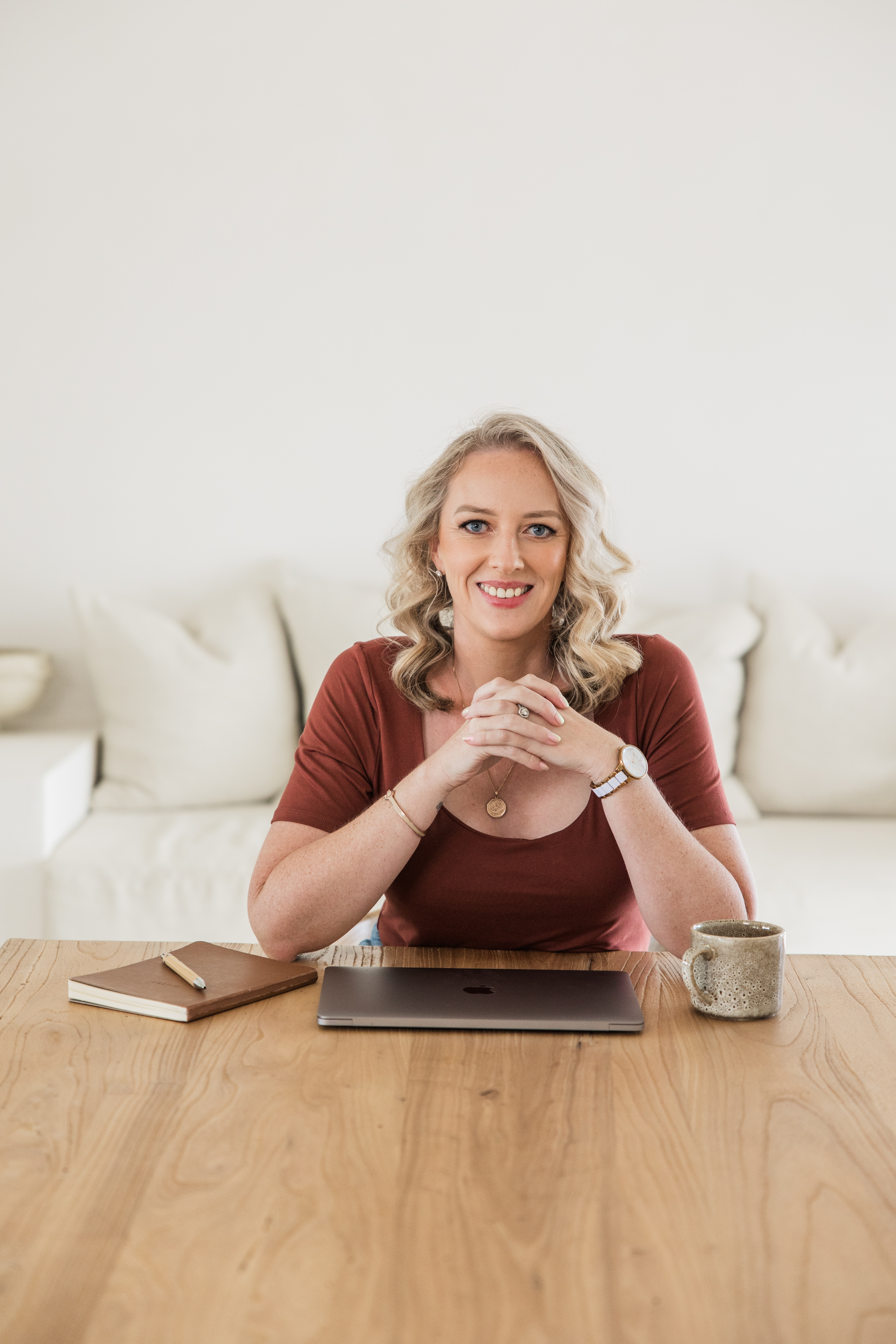 Elle Harrison, founder of Alveya, seated at a desk with a notebook and laptop
