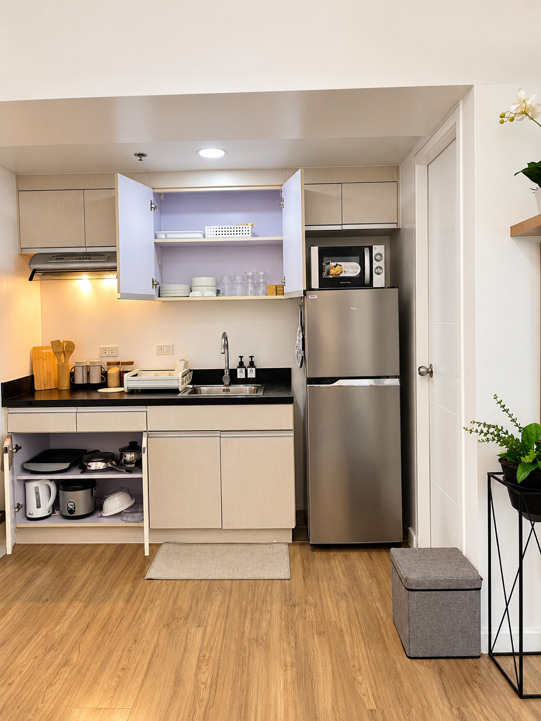 Casa Tresoria kitchen with refrigerator, microwave, sink, cabinets, cookware, kettle, and rice cooker