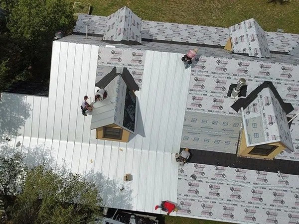 roofers installing metal roofing on new home