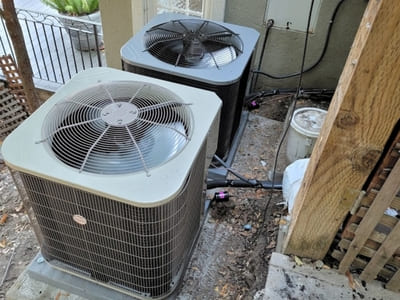 Two outdoor air conditioning units installed side by side, providing energy-efficient cooling for a residential home.