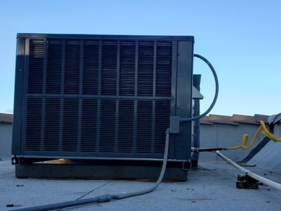 Rooftop air conditioning unit installed for a commercial building, maintained for optimal cooling and energy efficiency.