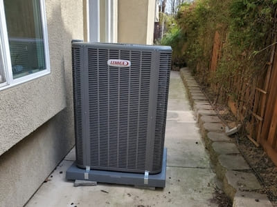 Outdoor Lennox air conditioning unit placed beside a home, designed for optimal cooling performance and energy efficiency.