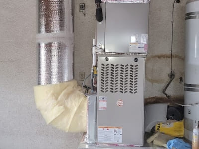 Residential HVAC furnace unit installed in a garage, maintained to ensure effective heating and proper ventilation for optimal performance.