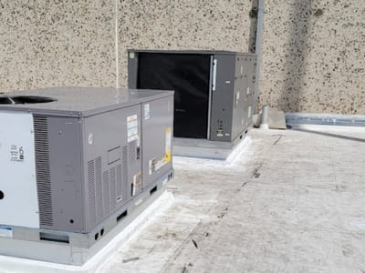 Two rooftop commercial HVAC units installed to provide efficient cooling for a large commercial space.