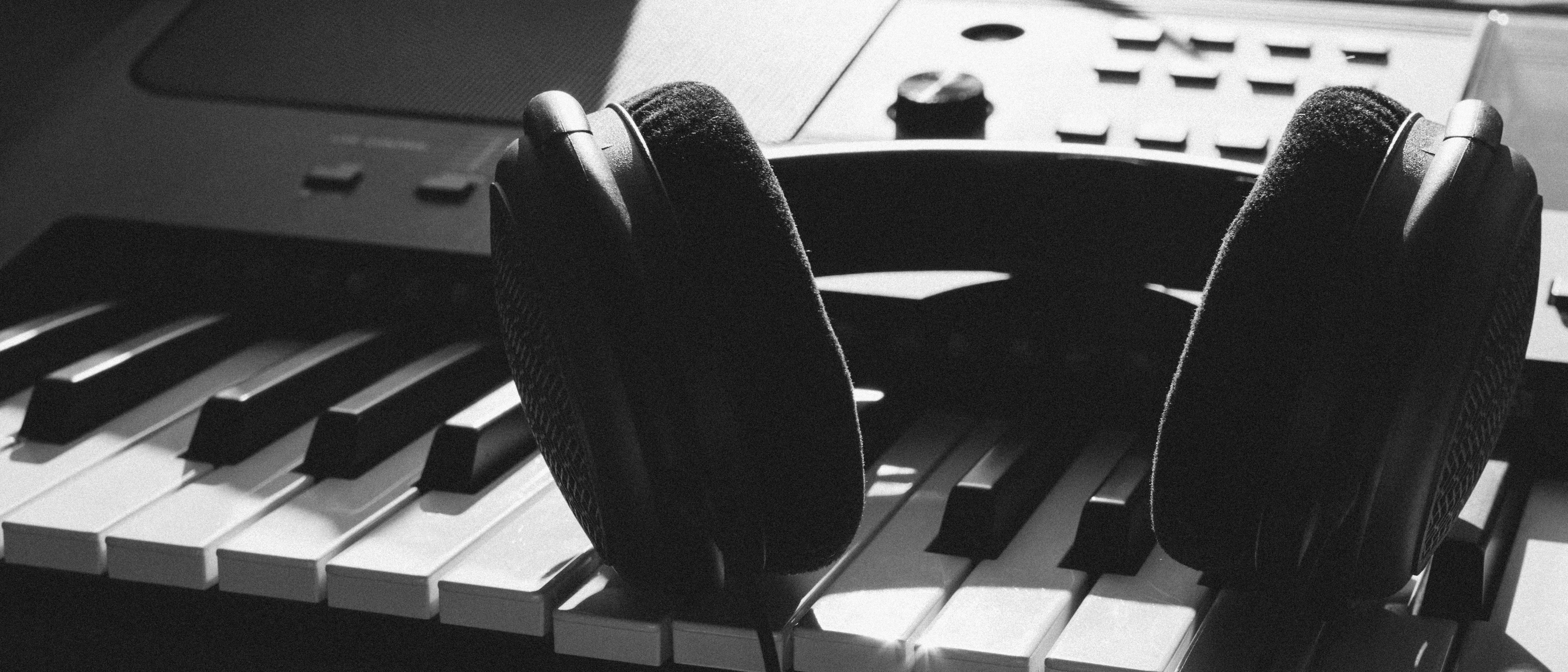 black and white image of headphones on keyboard piano black and white image of headphones on keyboard piano