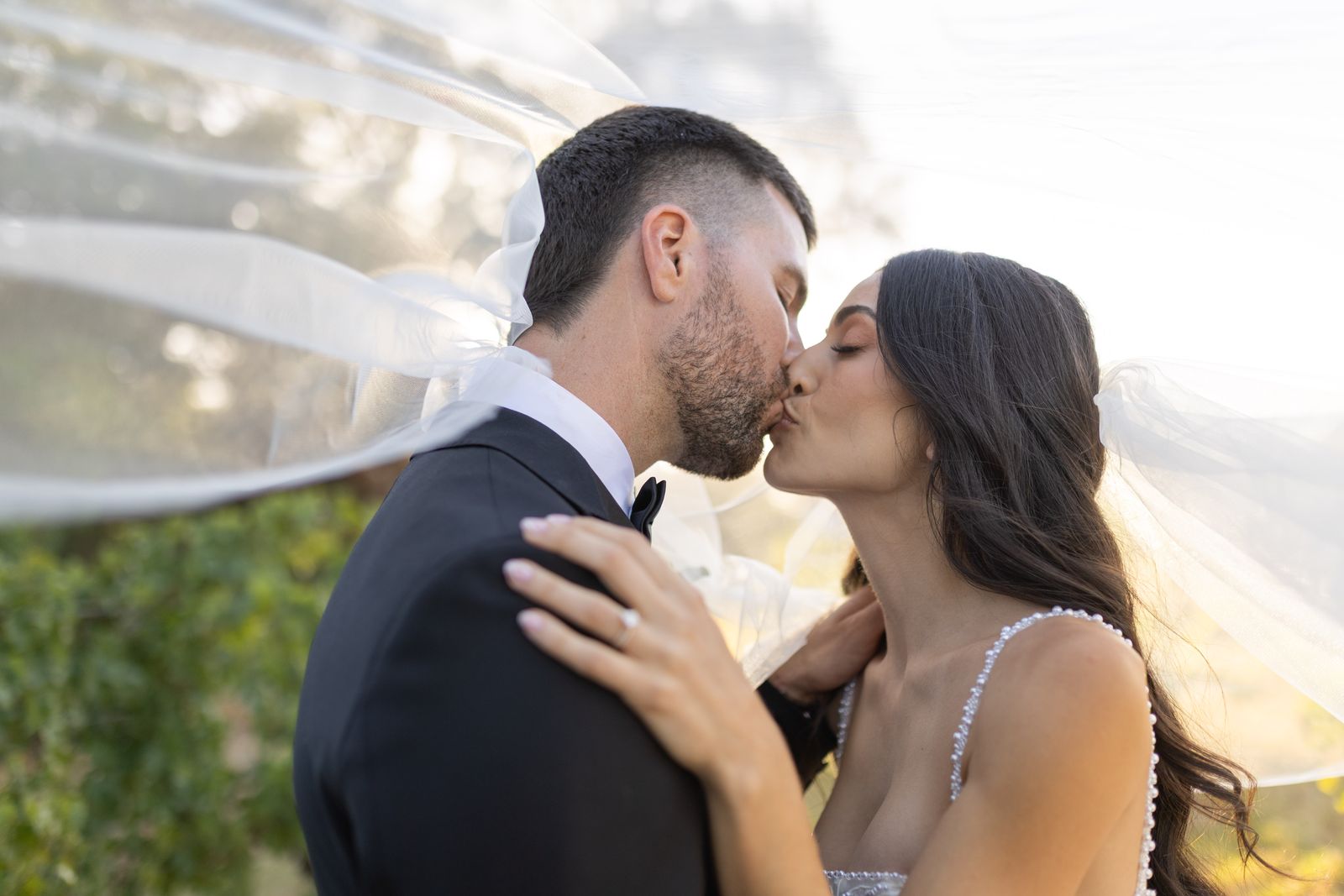 Close kiss in golden light with the veil drifting across