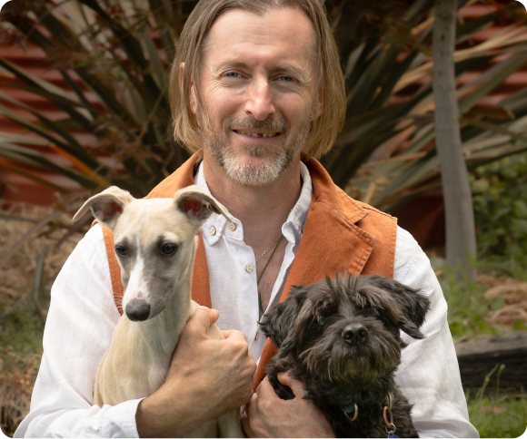 Photo Of Dr. Ed Holding Two Dogs