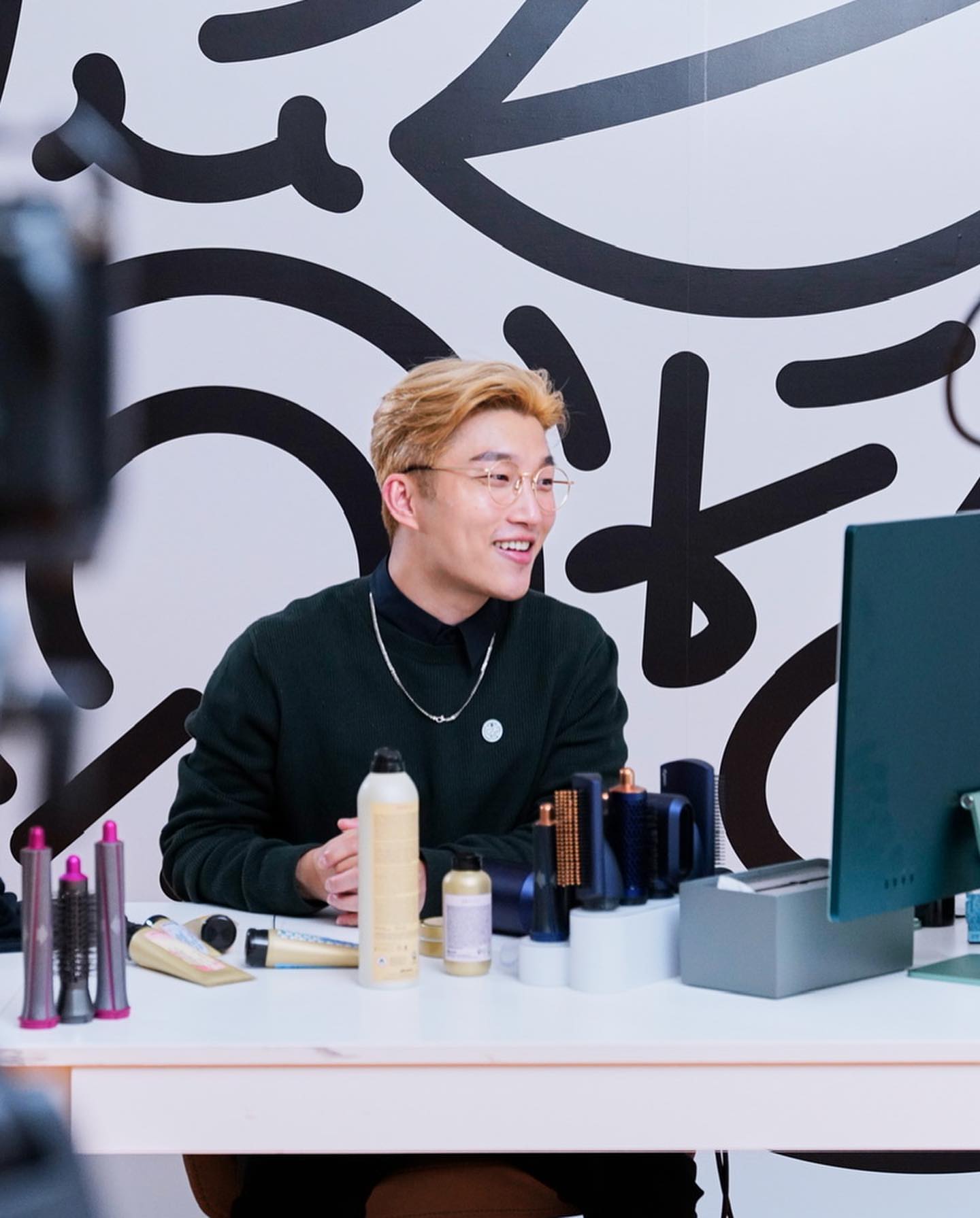Ricky 在桌前示範護膚用品