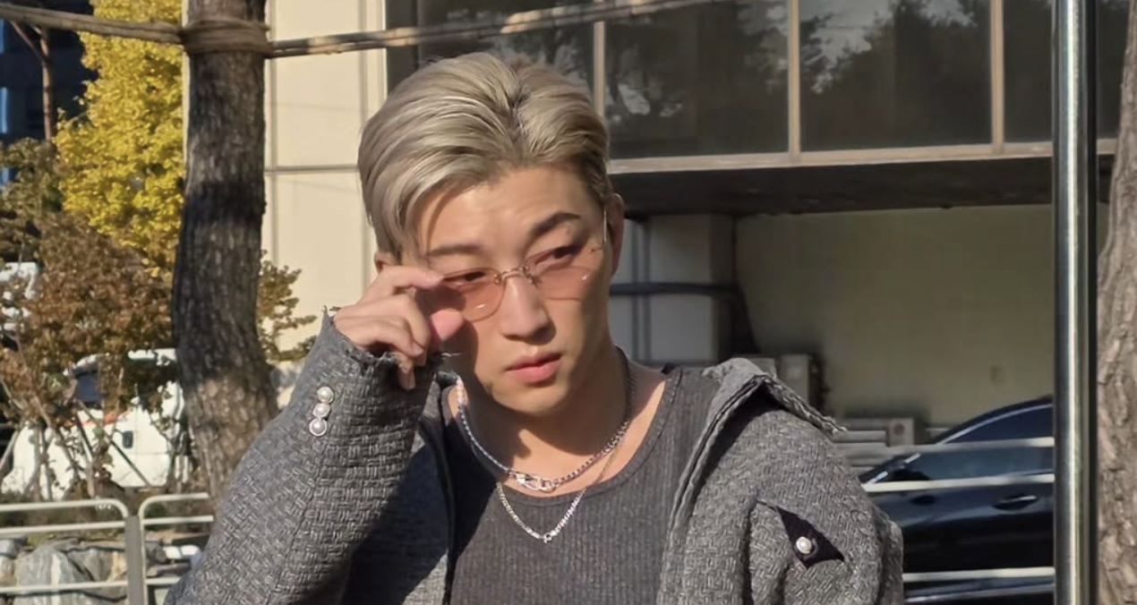 Ricky 在戶外整理眼鏡的近照