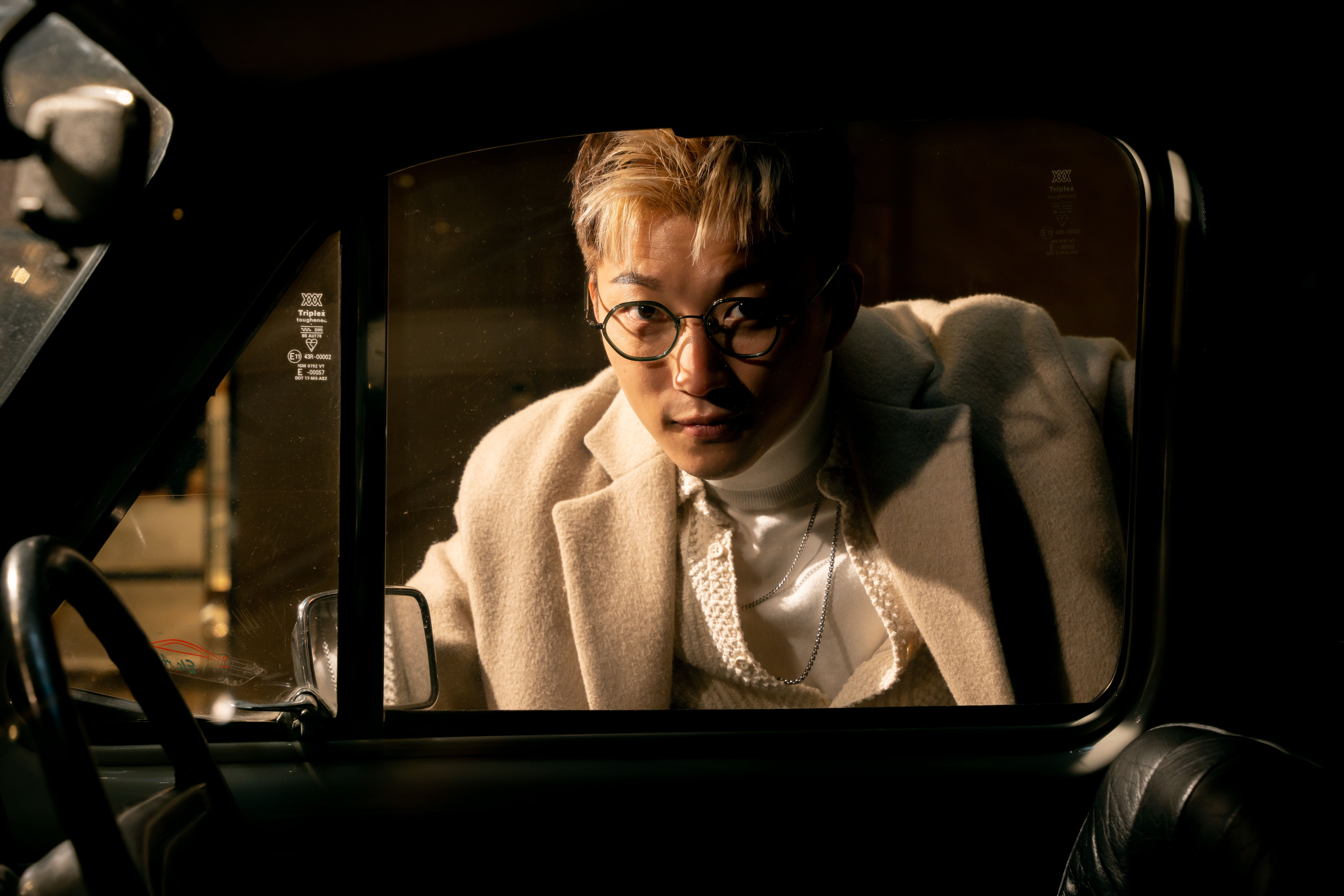 Ricky 穿白色西裝在夜間車廂內