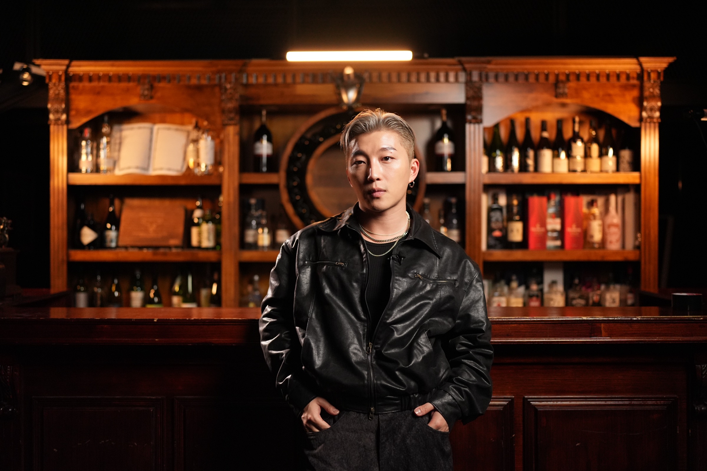 形象專家 Ricky Kazaf，身穿黑色皮褸在暖木色酒廊