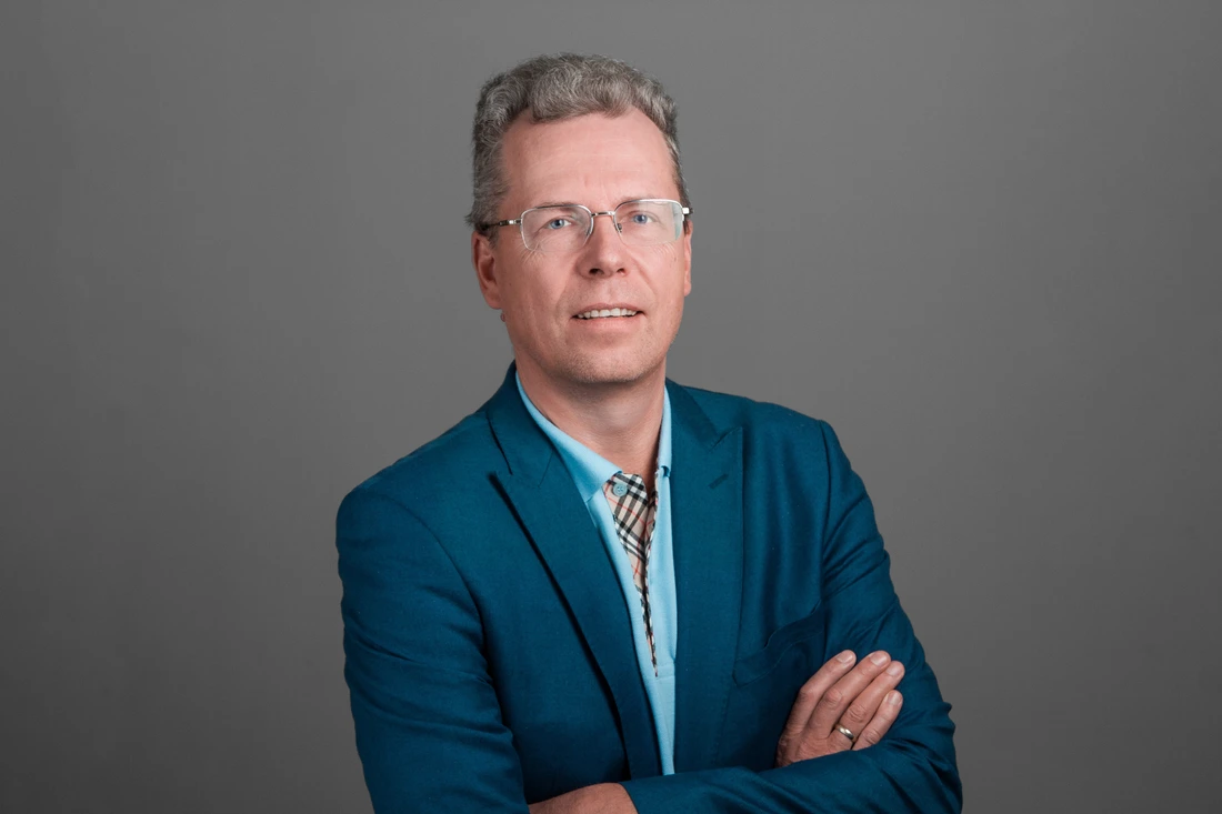 Portrait of Ugis Strauss in a blue blazer.