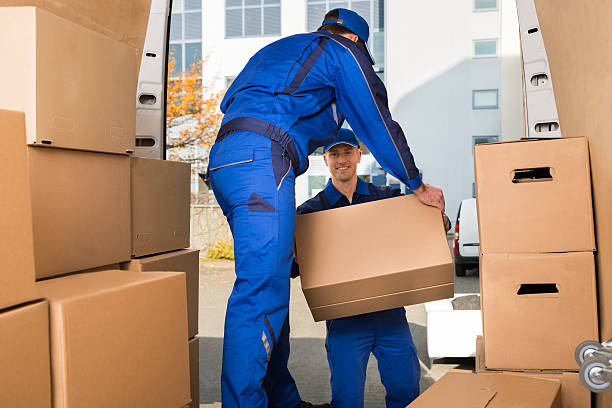 Two professional movers loading boxes into a moving truck. Two professional movers loading boxes into a moving truck.