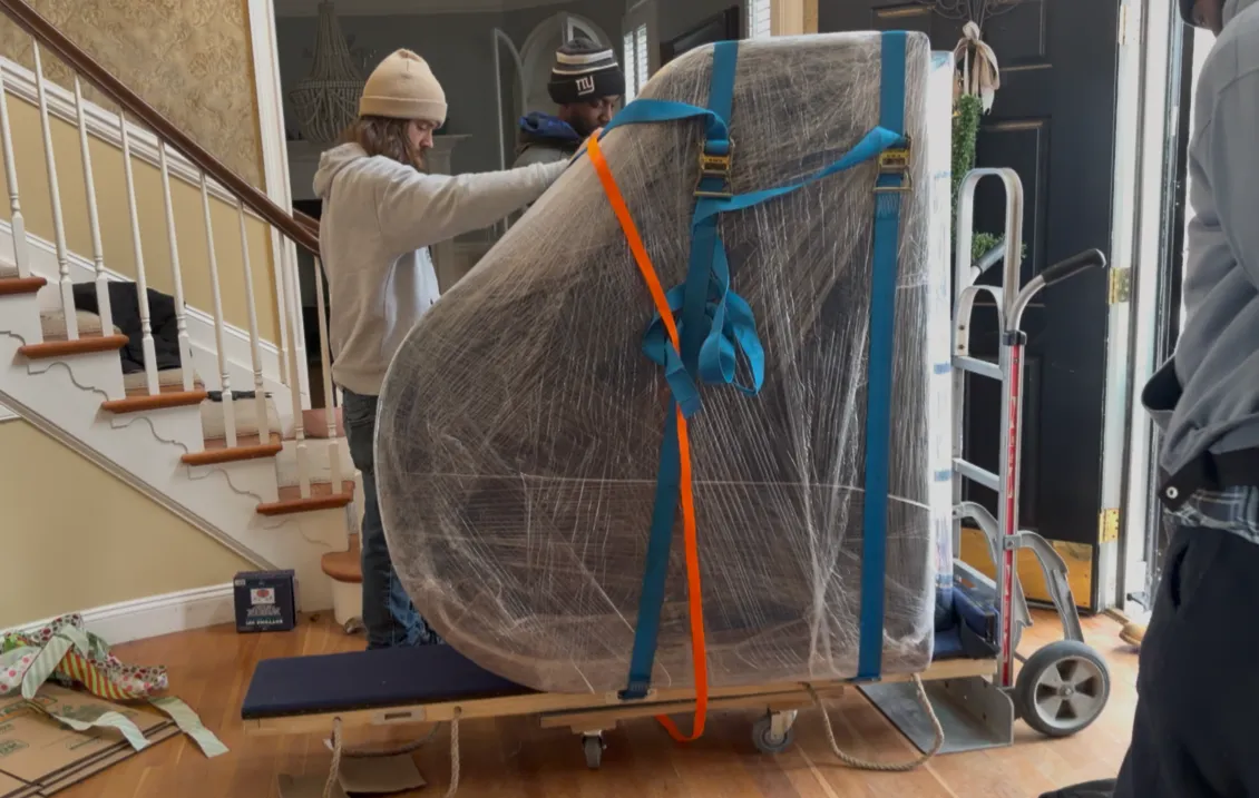 Crew member carefully padding and protecting a large specialty item before a move — Keep It Moving Services