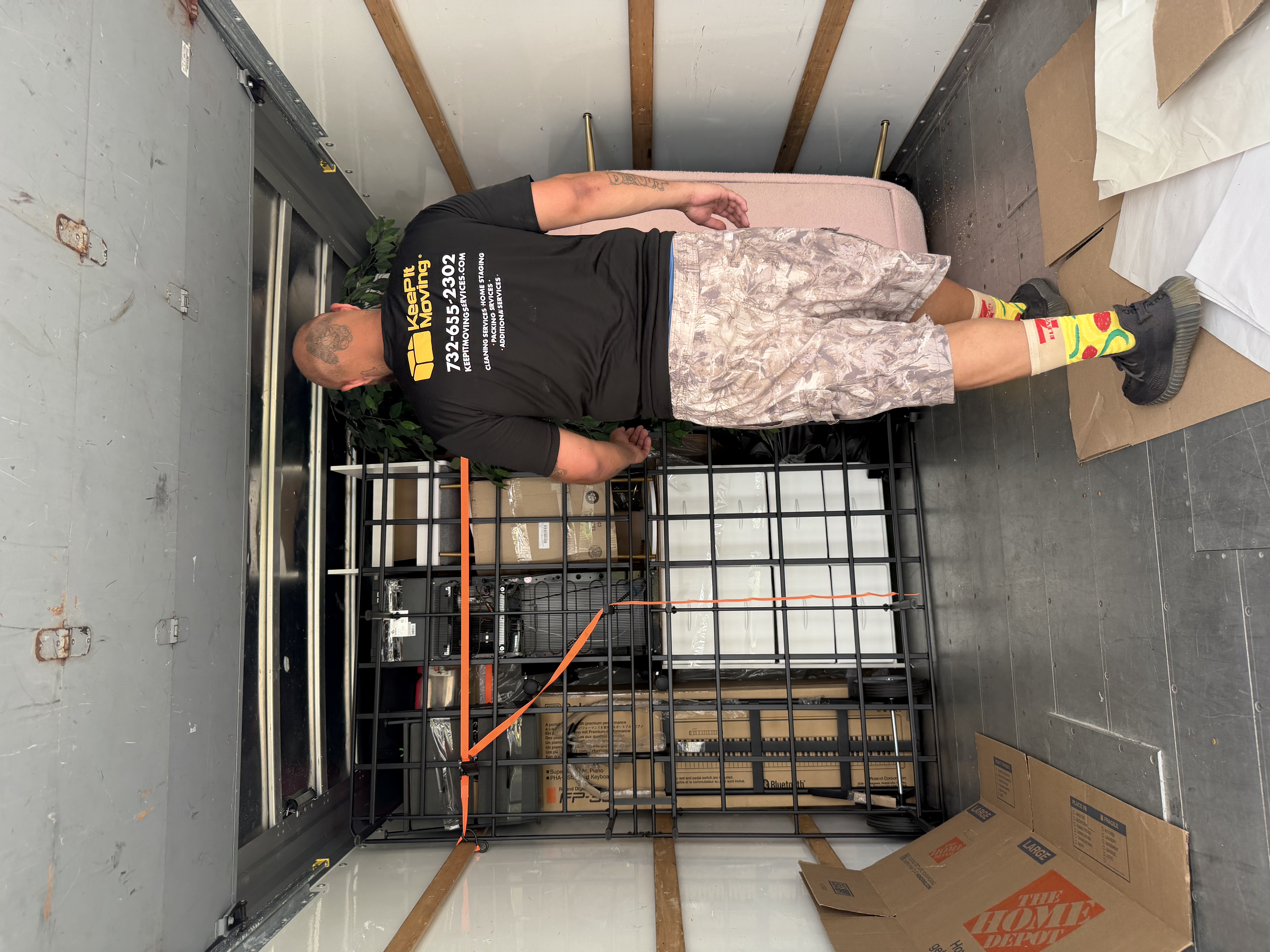 Keep It Moving Services crew member securing a heavy wire rack with ratchet straps inside a moving truck, the kind of garage load Hunterdon County movers handle